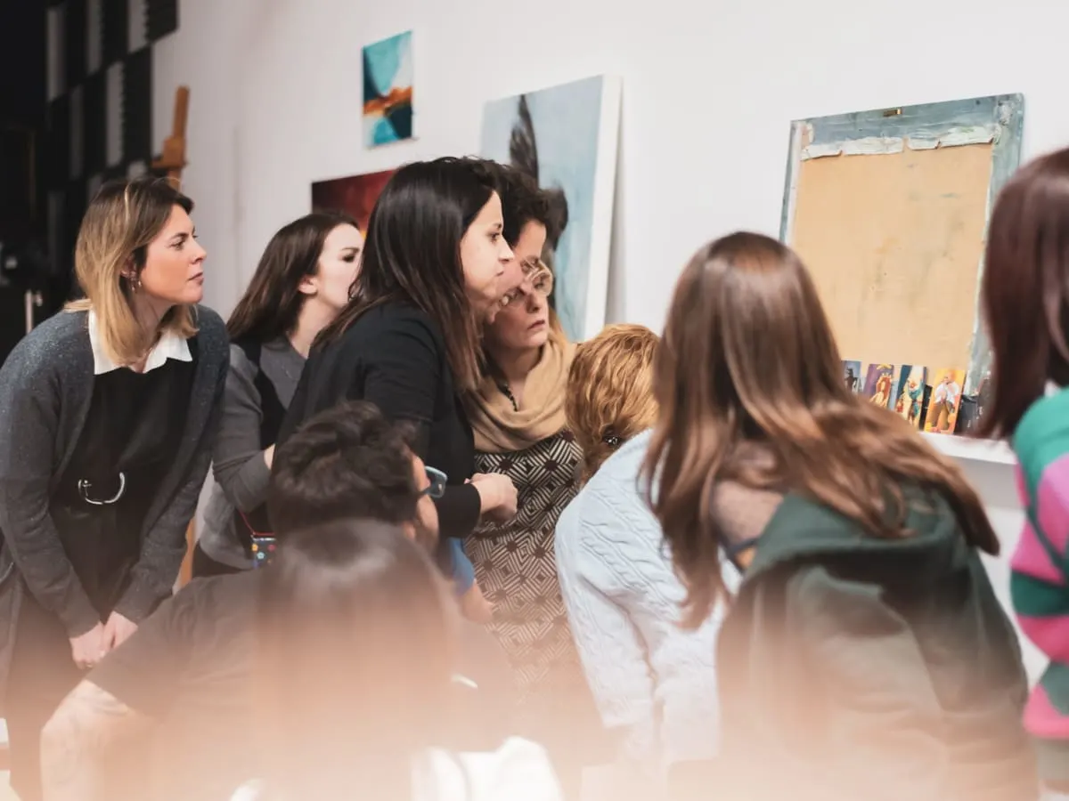 Una serata community: persone davanti alle opere esposte