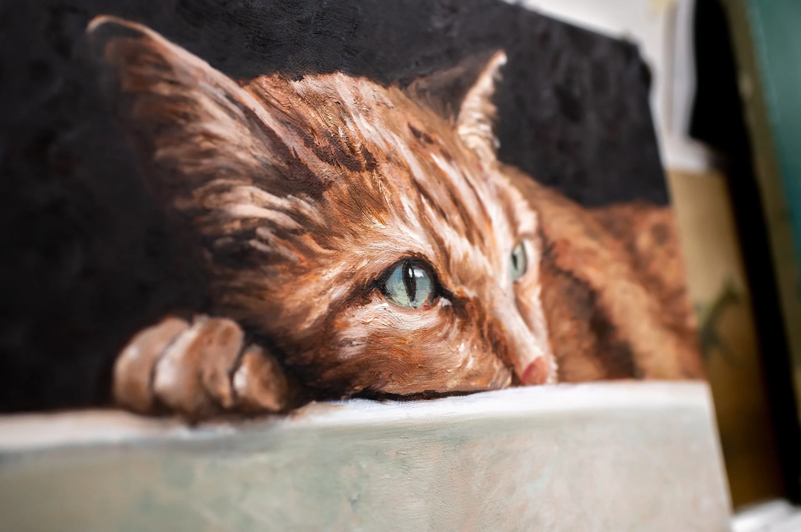 Il ritratto a olio di un gatto rosso che guarda fuori dalla tela