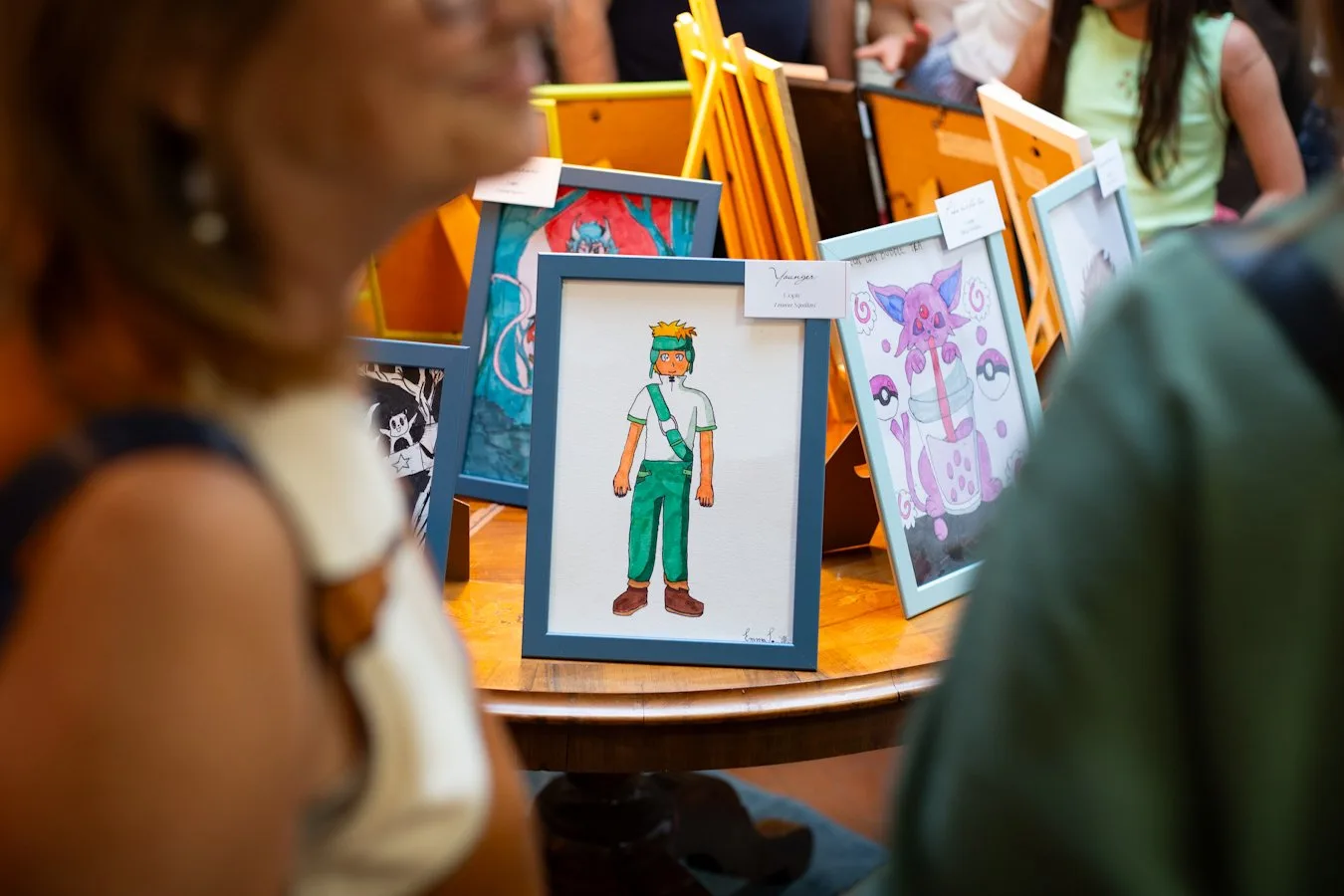 Piccoli quadri incorniciati su un tavolo rotondo della mostra