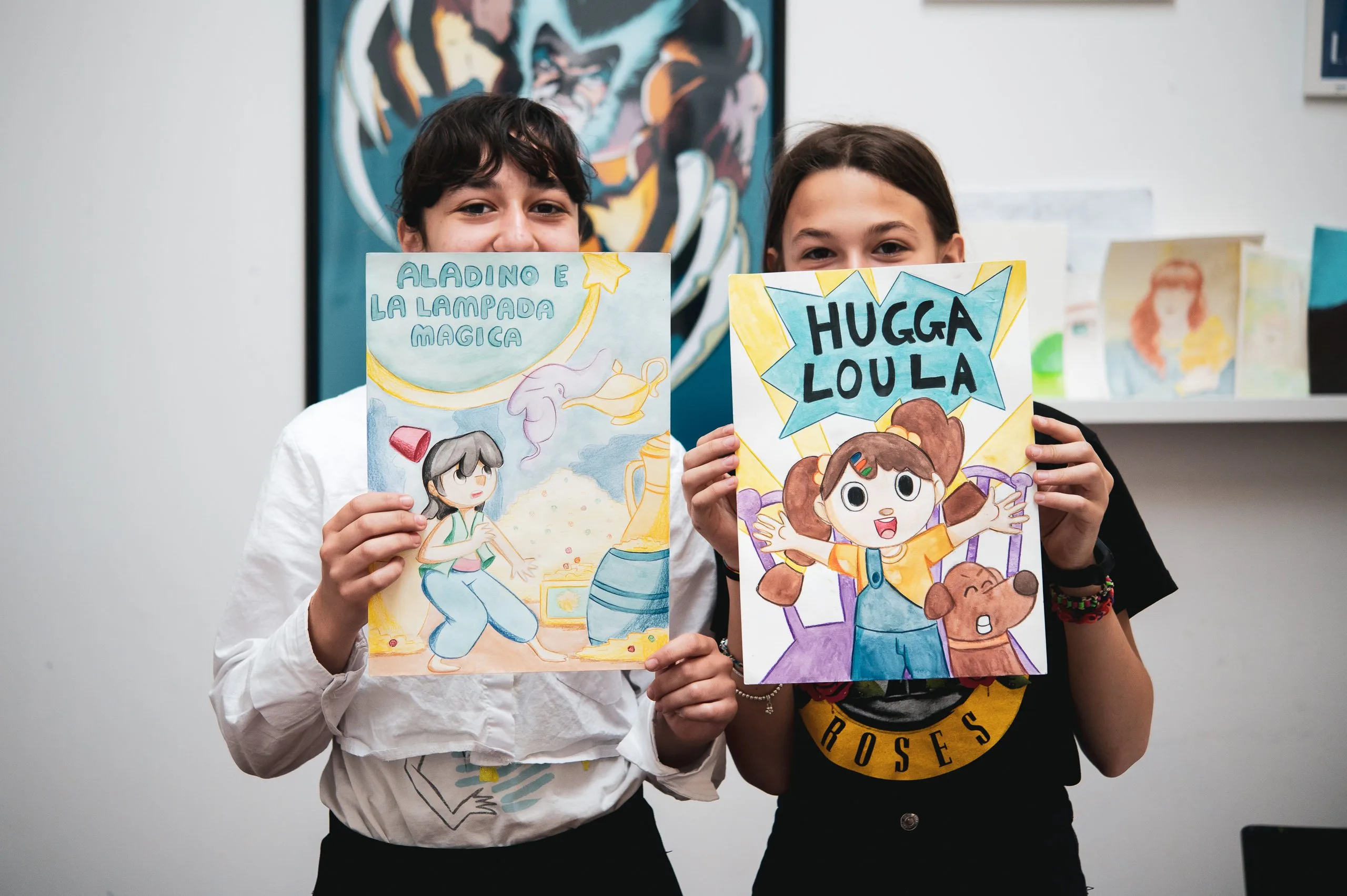 Due ragazzi mostrano i libri che hanno illustrato durante il corso